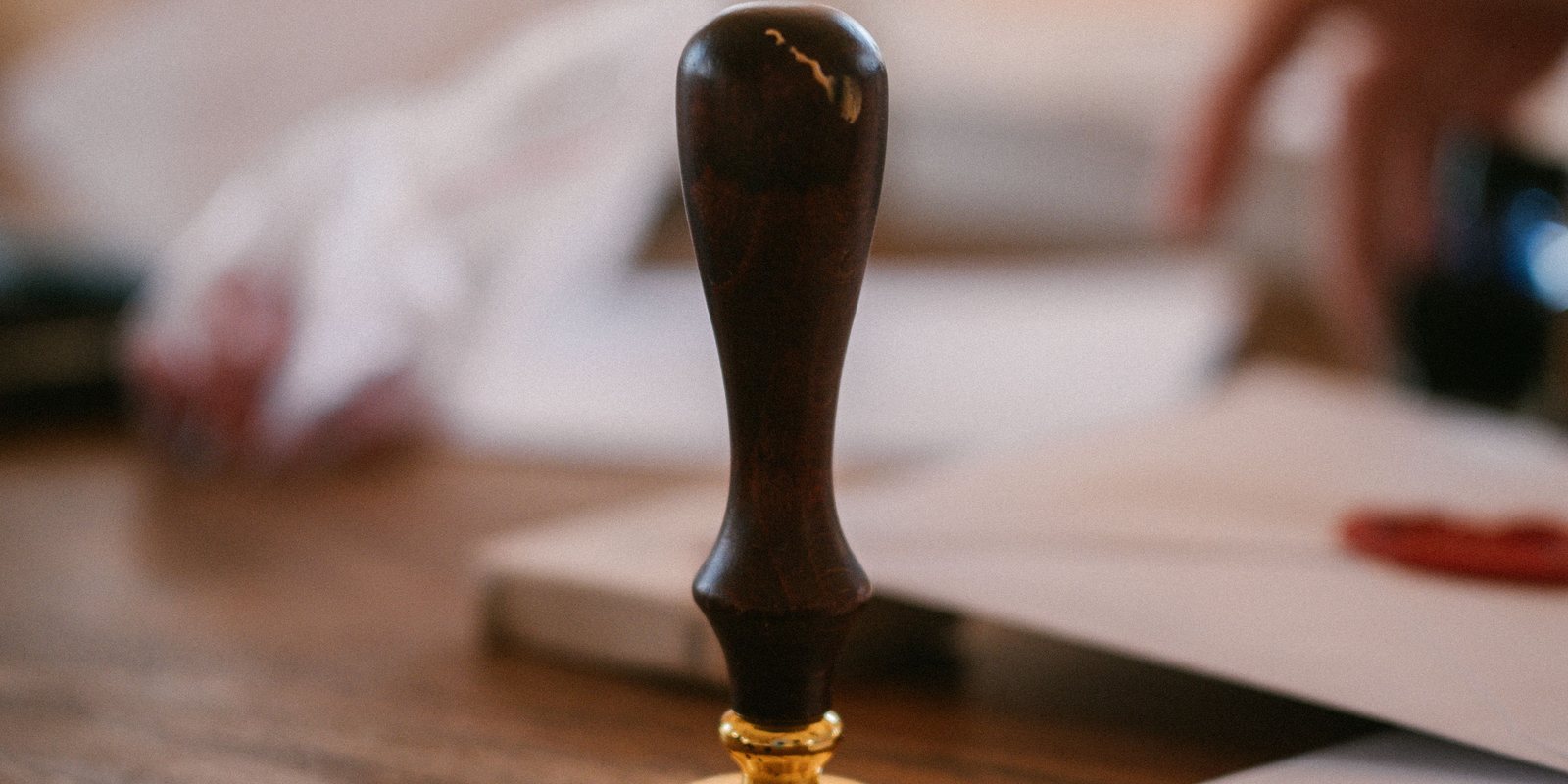A wooden seal stamp standing on printed documents.